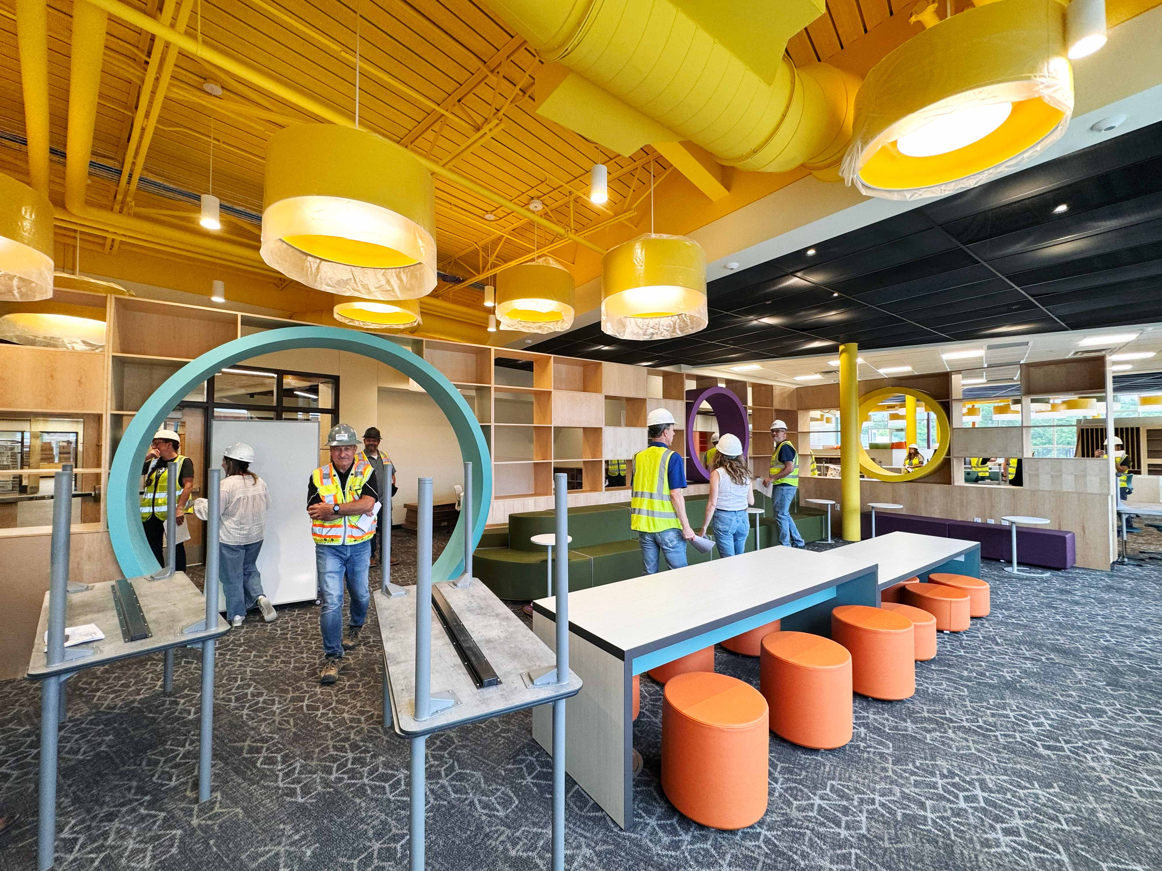 The second floor media center with a bright yellow ceiling, flexible furniture, and book shelves